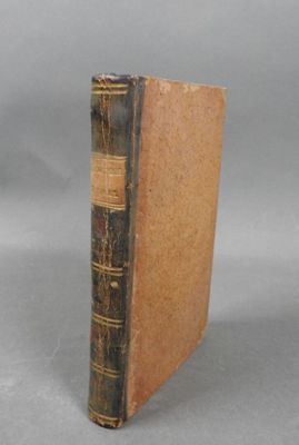 an old book sitting on top of a table next to a gray background