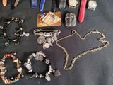 many different types of jewelry on a black table