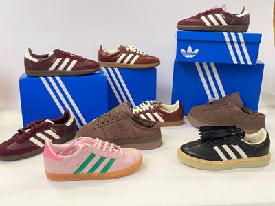 Plusieurs paires de baskets adidas sont exposées dans un magasin