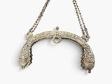 an antique silver plated purse with a chain hanging from it