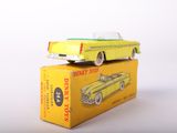 yellow toy car sitting on top of a yellow box on a white surface
