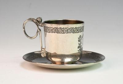 a silver cup and saucer on a saucer