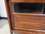 un meuble en bois avec une porte en verre dans une pièce