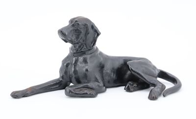 statue représentant un chien noir couché sur une surface blanche