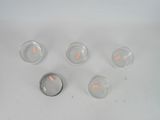 five lit candles sitting in a row on a white table