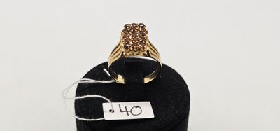 un gros plan d'une bague en or posée sur un présentoir noir