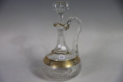 a clear glass bottle with a gold decoration on it