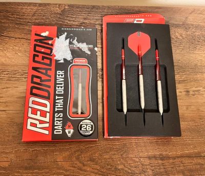two red and white darts in a red box on a wooden table