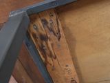 une table en bois avec des pieds en métal et un plateau en bois