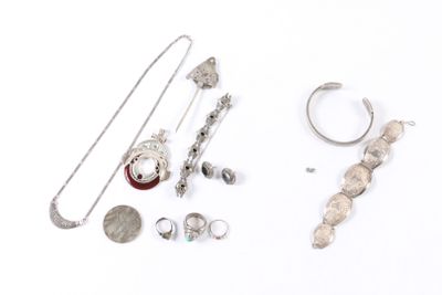 beaucoup de bijoux en argent sur une surface blanche