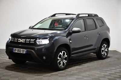 Une Dacia grise est garée dans une pièce au sol en damier
