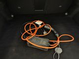 a car trunk with an orange cord and a charger in it