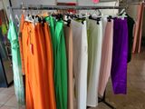 many different colored pants hanging on a rack in a store
