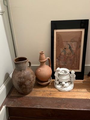 quelques vases sont posés sur une étagère en bois à côté d'un tableau