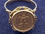 a close up of a gold ring with a coin on it