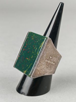 un gros plan d'une bague ornée d'une croix