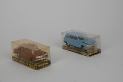 deux petites voitures miniatures dans une boîte transparente posée sur une surface blanche
