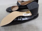 pair of women ' s black shoes on a white surface