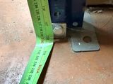 a measuring tape on the floor next to a piece of metal