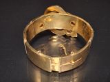 a close up of a gold bracelet on a black surface