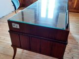 a table with a glass top and a chair in a room