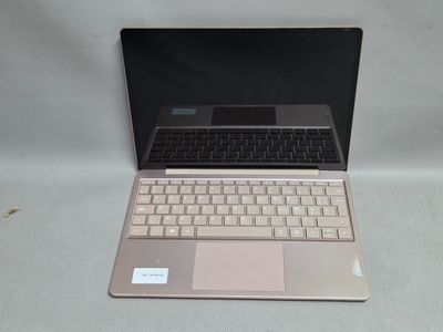 un ordinateur portable posé sur une table blanche