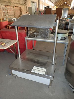 une étagère métallique sur laquelle est accrochée une pancarte, dans un entrepôt