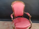 pair of pink chairs with gold trim and wooden arms