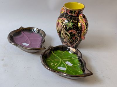 three different colored vases sitting next to each other on a table