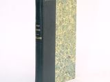a black book with a green cover on a white surface