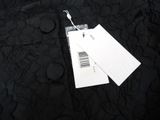 a tag that is attached to a black dress