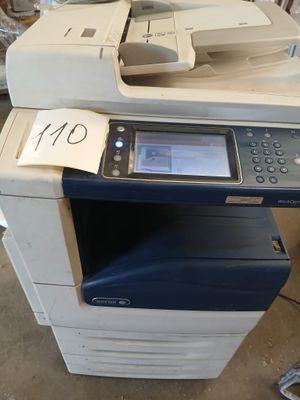 une imprimante multifonction posée au sommet d'un tas de bric-à-brac