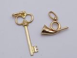 two gold keys and a key ring on a white surface
