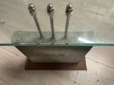 a glass table with three metal poles on top of it