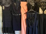 un grand nombre de robes suspendues à une étagère dans une pièce