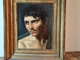 painting of a young man in a gold frame on a table