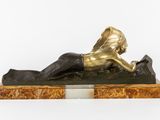 bronze statue of a woman laying on a marble base