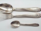 three spoons and a fork on a white table