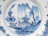 blue and white plate with a bird and a pagoda on it