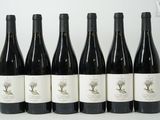 six bouteilles de vin sont alignées sur une table