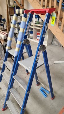 three ladders that are sitting in a room