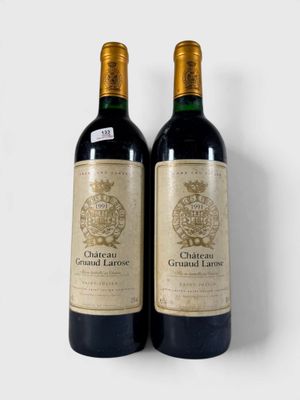 deux bouteilles de vin posées l'une à côté de l'autre sur une surface blanche