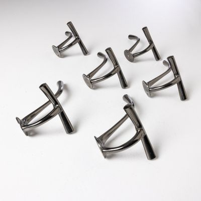 six pairs of silver cuff rings on a white surface