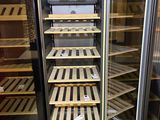 many shelves of wine bottles in a glass case