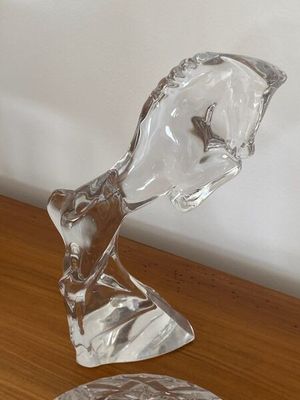 une sculpture en verre représentant une tête d'homme posée sur une table en bois