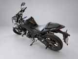 the black motorcycle is parked on the white floor in the studio