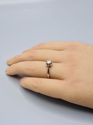 la main de quelqu'un, avec une bague en diamant au doigt
