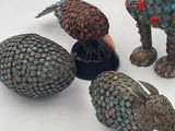 several figurines of animals and birds are sitting on a white surface