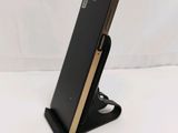 a close up of a cell phone on a stand on a white surface