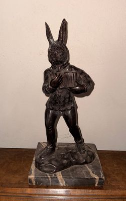 une statue représentant un lapin tenant un panier posé sur une table